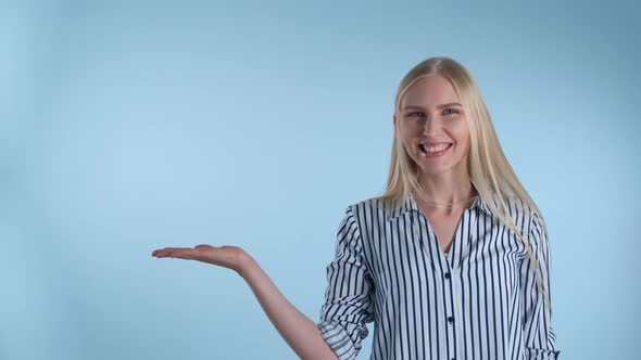 Pretty Woman Presenting Something on Empty Hand with Blue Background