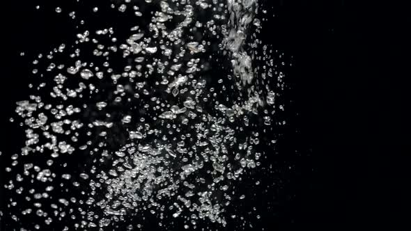 Slow Motion Stream of Water Drops Down in Aquarium on a Black Background