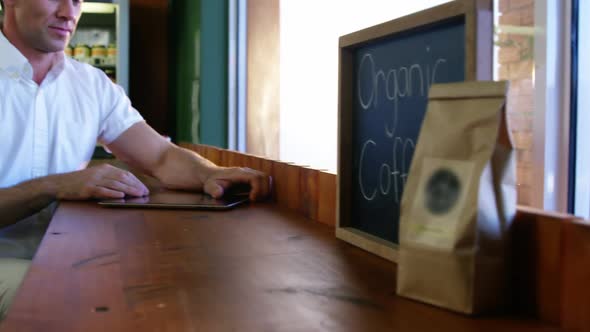 Woman giving cup of coffee to man in caf������������