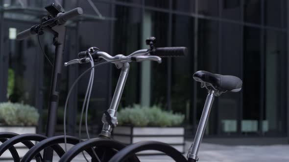 Closeup Bicycle Standing at Parking Lot with Electric Scooter