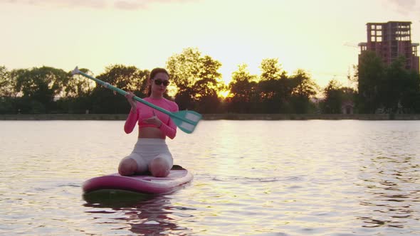 Young Woman in Sport Clothes Swimming on Paddle Board