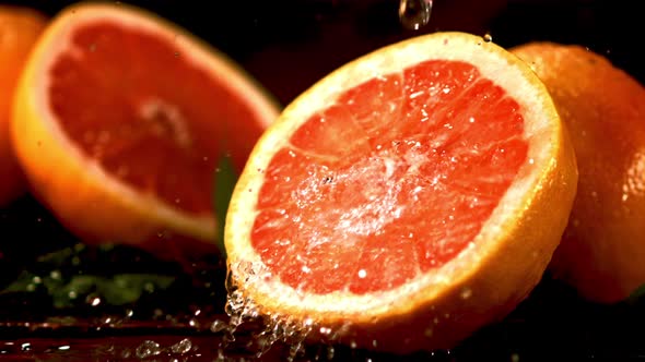 Super Slow Motion on a Piece of Fresh Grapefruit Dripping Water