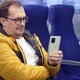 Guy in Glasses Looks Social Media Texting Messages Using Cell Phone While Riding Home By Train - VideoHive Item for Sale