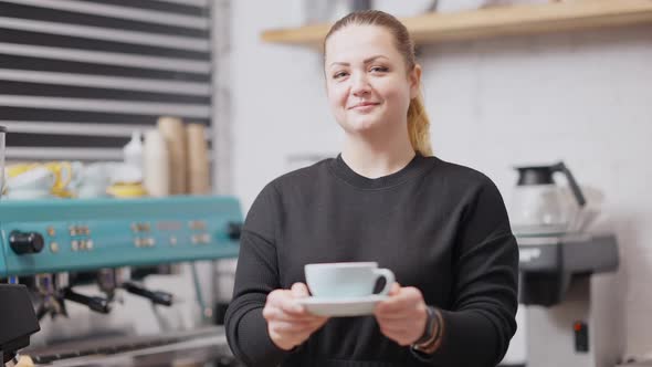 Positive Charming Plussize Woman Stretching Coffee Cup in Slow Motion Smiling at Camera