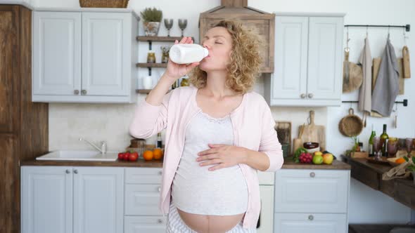 Young Pregnant Woman Taking Medicine Against Heartburn On Her Kitchen. Symptomatic Relief.