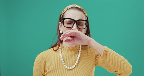 Tired woman is yawning looking at the camera and touches her forehead. Isolated.