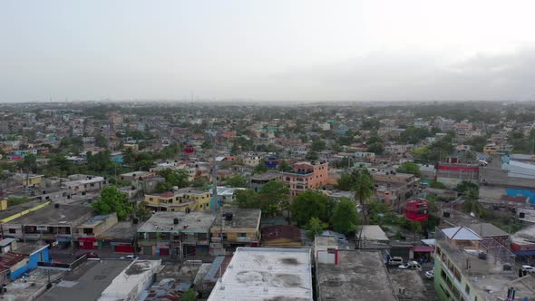 Drone Hovers Above Dirty Residential Rooftops in Santo Domingo as Red White and Blue Cable Cars (Tel