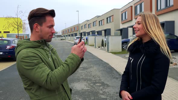 An Attractive Woman Poses for an Attractive Man To Take a Picture of Her on an Empty Street