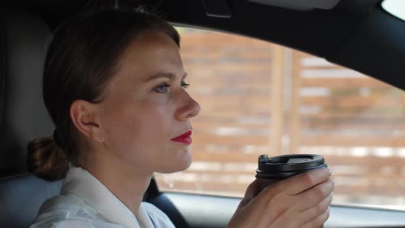 Portrait of Female Drinking Coffee Driving Car