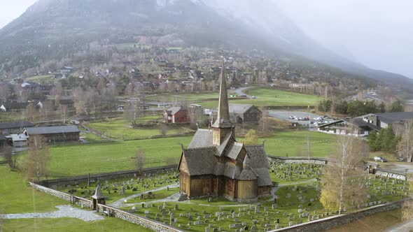 Lom Stave Church And Graveyard In Lom, Norway During Snowstorm Weather. Aerial Orbit