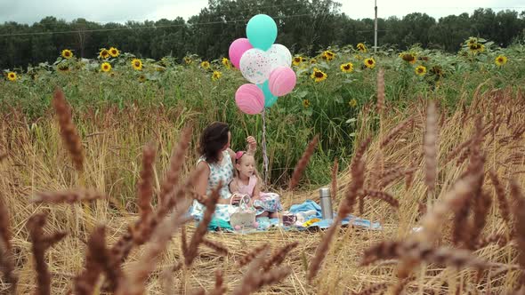 Mother with Little Daughter Picnicking in a Field