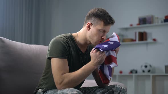 Male Soldier Kissing Folded USA Flag, Preparing to Comrade Funeral, Melancholy