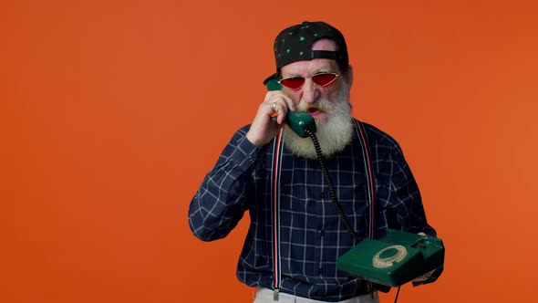 Crazy Elderly Bearded Old Man Talking on Wired Vintage Telephone of 80s Fooling Making Silly Faces
