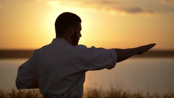 Silhouette of Man Training Karate at Sunset