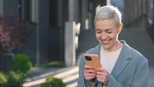 Business Woman Smiling Sincerely While Texting on Mobile