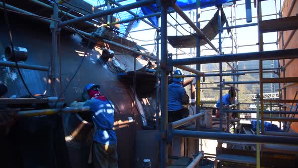 Workers Welding a Piece of Wind Turbine