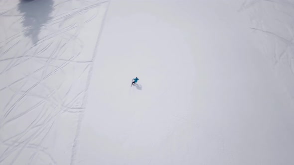 Aerial of ski resort at sun mountains with pine forest. Skiers ride down on snow slope at lifts. Win