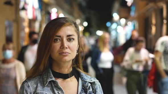 Woman Looks at Camera Smiles and Poses for Face Portrait on Evening Street