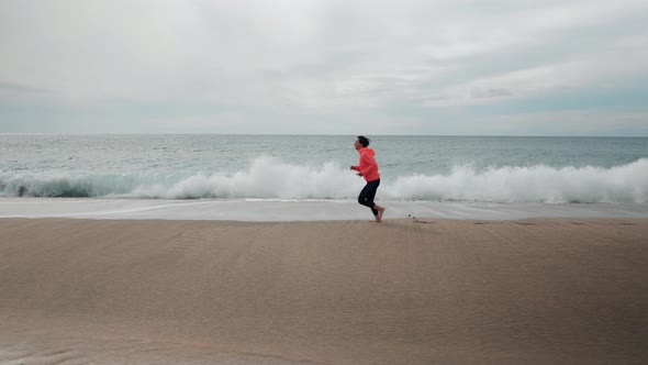 Woman running near ocean waves