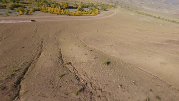 FPV Sports Drone Shot Panorama View SUV Automobile Extreme Riding on Sandy Path Desert Mountain