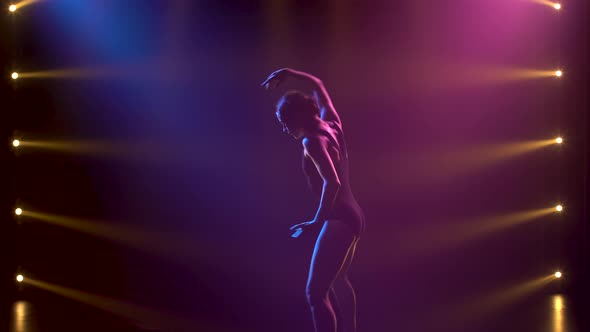 Professional Ballerina in Black Bodysuit Gracefully Dancing Ballet in Dynamic Spotlights and Smoke