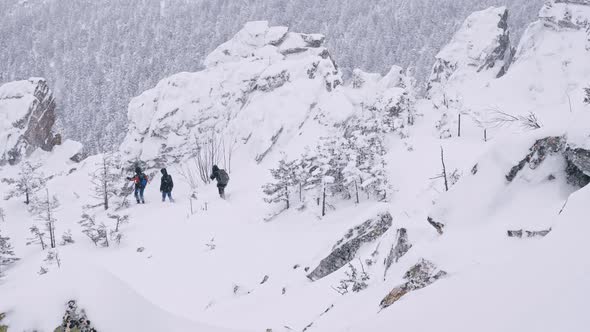 A Group of Tourists Descends From the Top of a Snow-covered Mountain