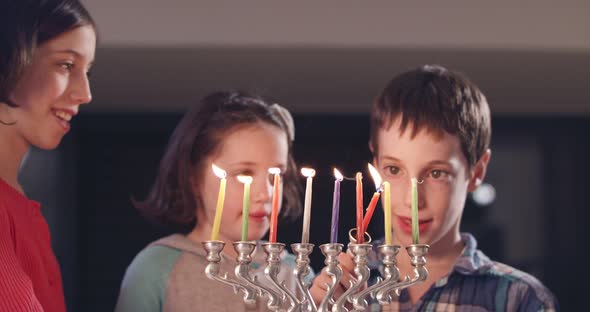 Children lighting Hanukka candles at home