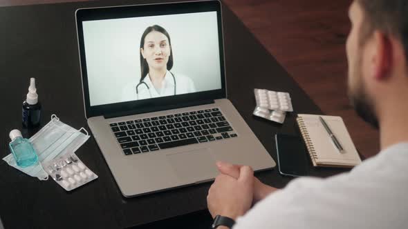 Back View of Man Making Video Call with Doctor While Staying at Home