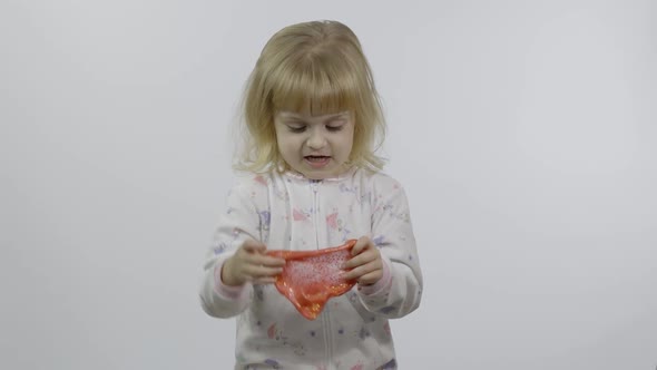 Kid Playing with Hand Made Toy Slime. Child Having Fun Making Red Slime