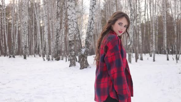 Female in Checkered Shirt Walking in Snowy Park