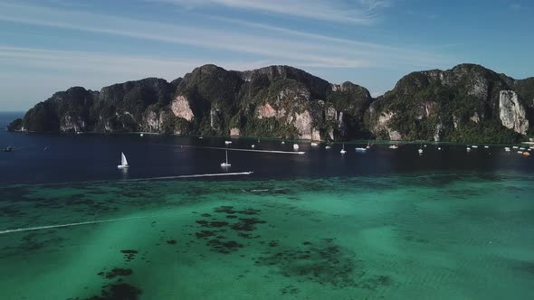 Aerial shot of the yachts, boats floating and moving. Turquoise clear water. Water Gradient from lig
