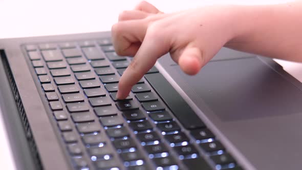 Hands of Small Child Press Finger on Laptop Buttons
