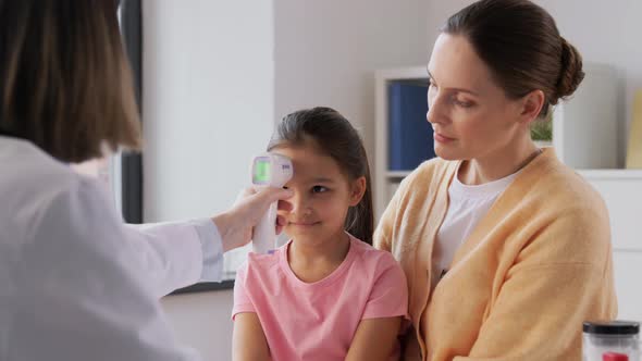 Mother with Sick Daughter and Doctor at Clinic