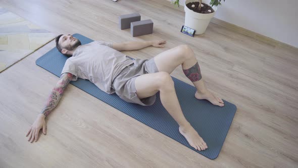 Young Man Practicing Relaxing Yoga Poses at Home for Healthy Lifestyle
