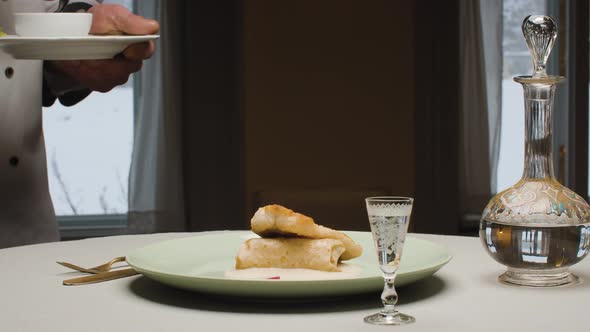 Chef Putting a Piece of Fish on a Plate with Pancake