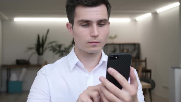 Businessman Using Smartphone in Office