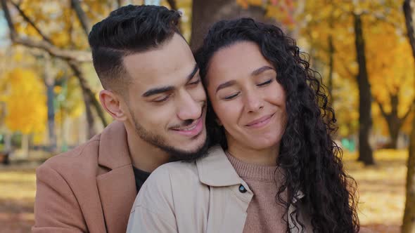 Hispanic Couple Cuddling Outdoors Girl and Guy on Romantic Date in Autumn Park Family Look Into Each