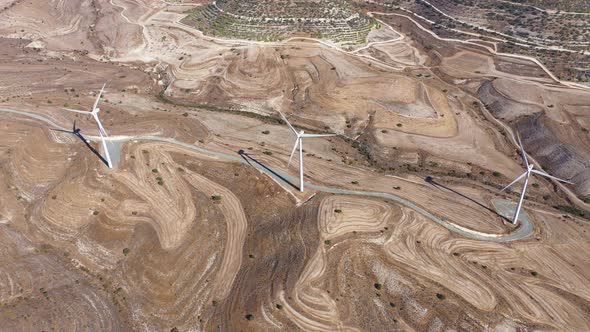 Boundless Fields with Shrubs and Road Against Wind Turbines