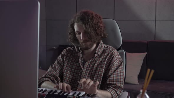 A Male Composer Works in a Recording Studio
