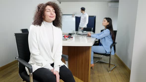 Portrait of Confident Gorgeous Caucasian Businesswoman Posing in Office Looking Back at Multiethnic