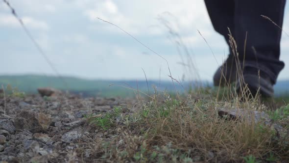 The Feet of the Tourist Step on the Rocky Ground