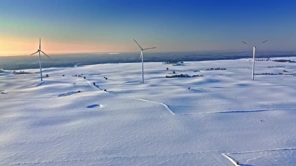 Wind turbines on snowy field. Alternative energy in winter, Poland.