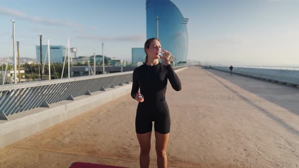 Cheerful Sportswoman Drinking Water During Break