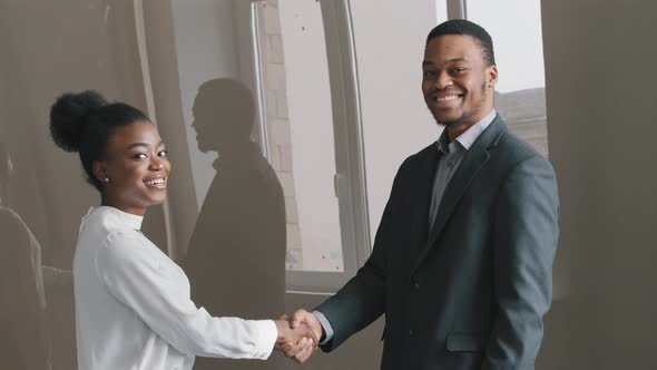 Happy Young African American Ethnicity Businesswoman Shaking Hands with Male Employer After Project