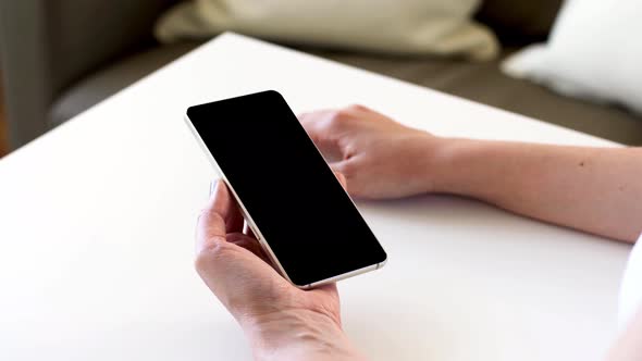 Hands Holding Smartphone with Blank Black Screen