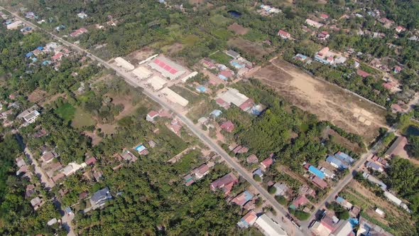 Aerial clip of outlying areas along Sangkae River in Battambang Cambodia during a summer day