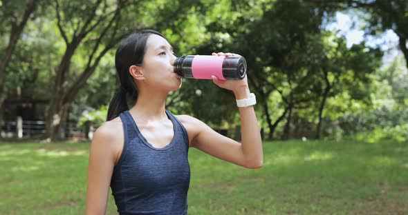 Sport Woman Drinking Water in The Park