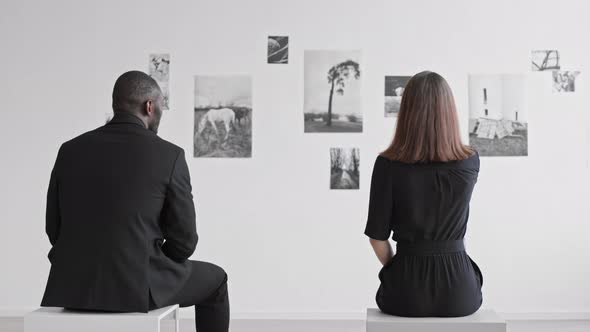 Couple Sitting in Art Gallery Rear View