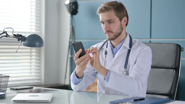 Doctor Using Smartphone While Sitting in Clinic