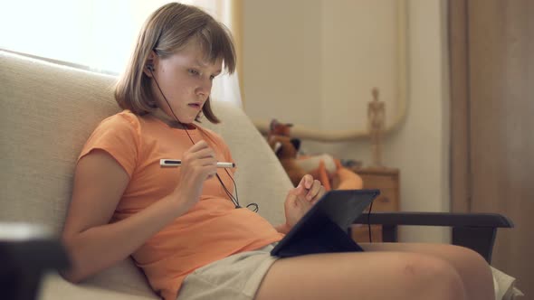 Teen Girl At Home On Couch Working In Tablet